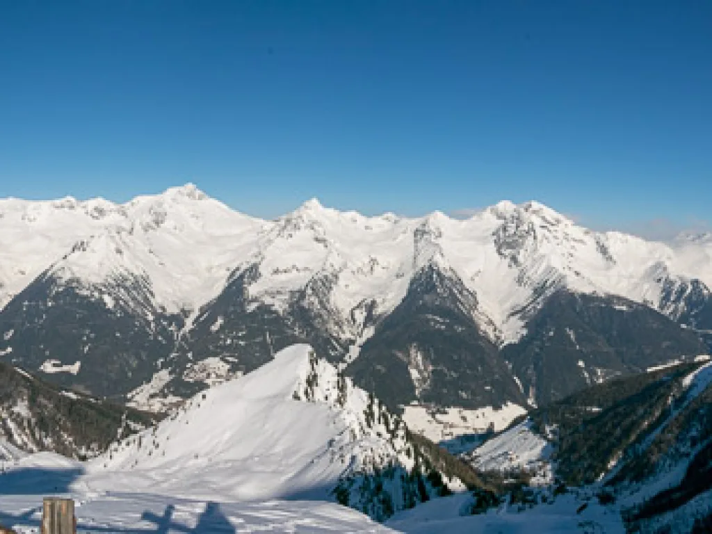 Weites Bergpanorama mit verschneiten Gipfeln.